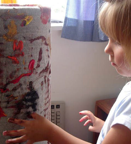 A young girl finger painting.