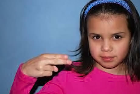 A young girl with special needs performing sign language.